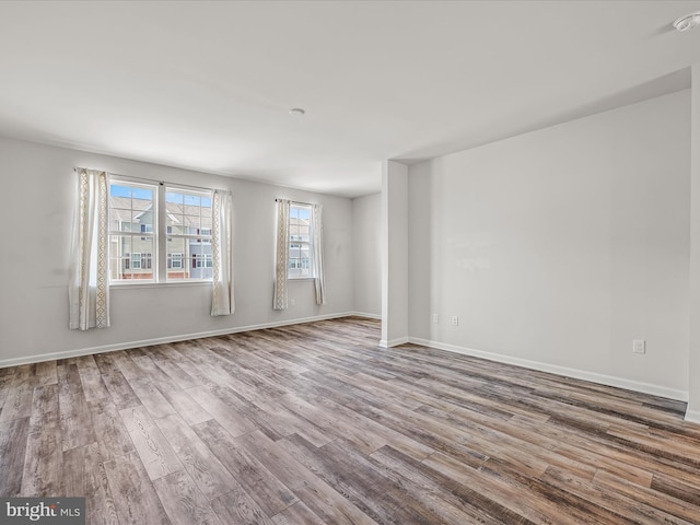 unfurnished room featuring wood finished floors and baseboards