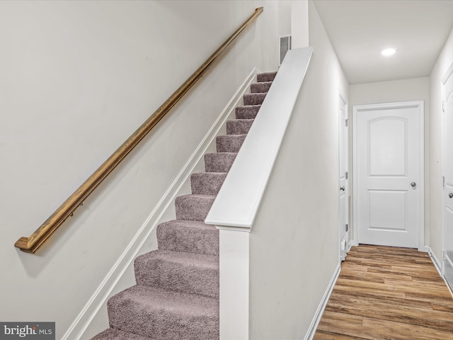 stairs with recessed lighting, visible vents, baseboards, and wood finished floors