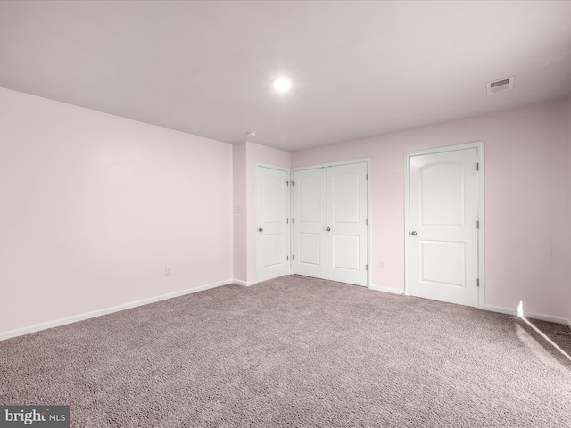 unfurnished bedroom featuring a closet, carpet, visible vents, and baseboards