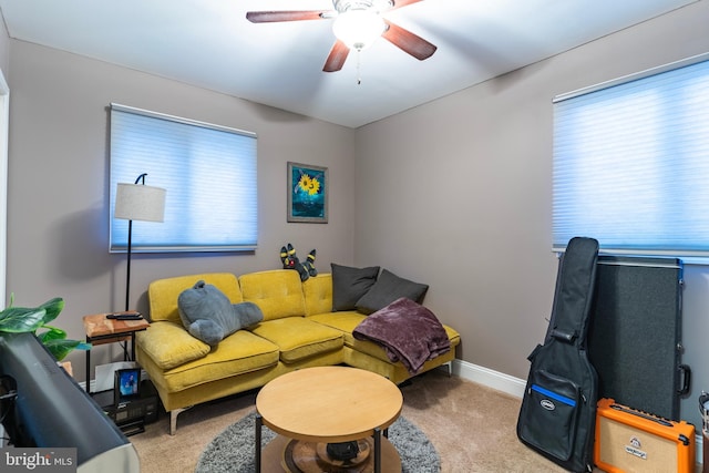 living room with ceiling fan, baseboards, and carpet flooring