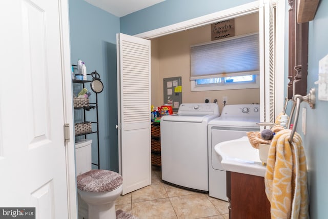 laundry area with laundry area, washer and clothes dryer, and light tile patterned flooring