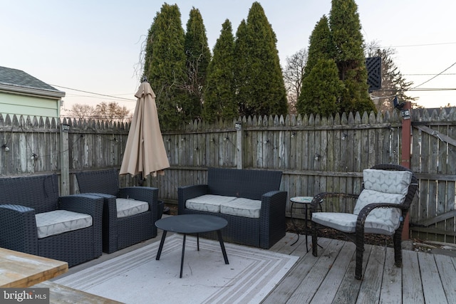 wooden terrace featuring outdoor lounge area and fence