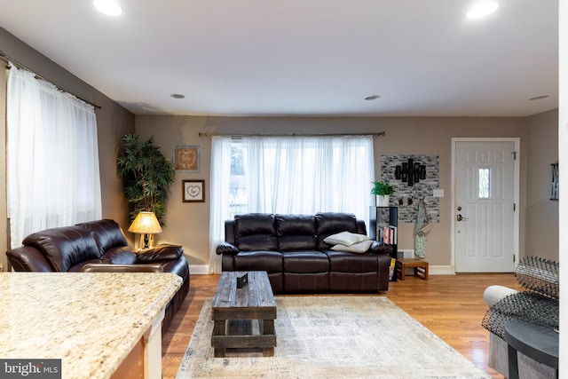 living room with baseboards, recessed lighting, and light wood-style floors