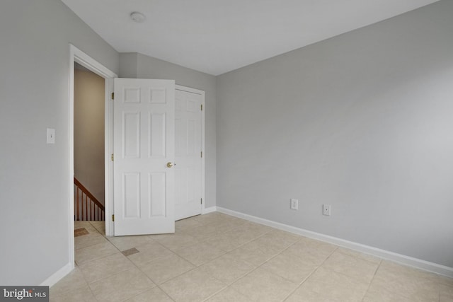 unfurnished bedroom featuring light tile patterned floors and baseboards