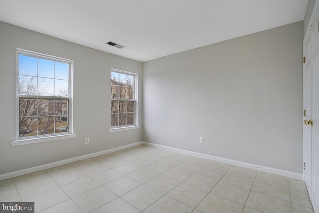 empty room featuring visible vents, baseboards, and light tile patterned flooring