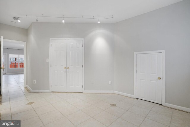 empty room featuring light tile patterned floors and baseboards
