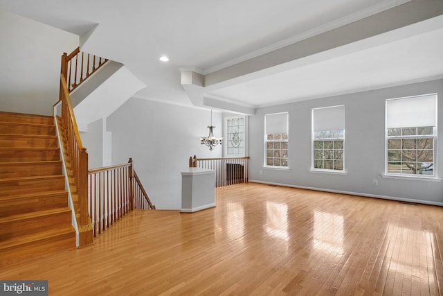 unfurnished living room featuring hardwood / wood-style flooring, plenty of natural light, and ornamental molding