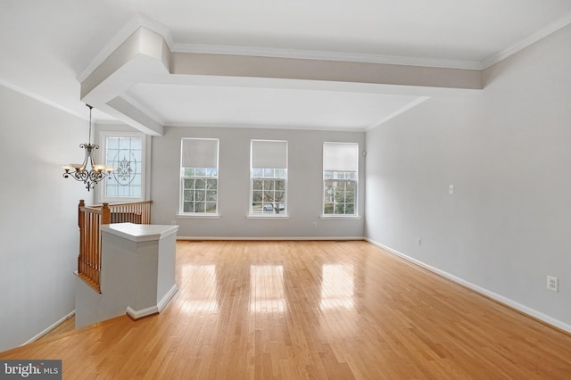 unfurnished living room featuring light wood-type flooring, baseboards, a chandelier, and ornamental molding