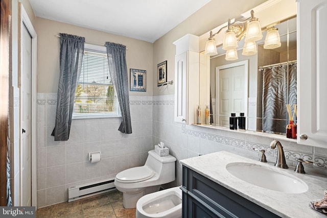 full bath with toilet, baseboard heating, vanity, a bidet, and tile walls