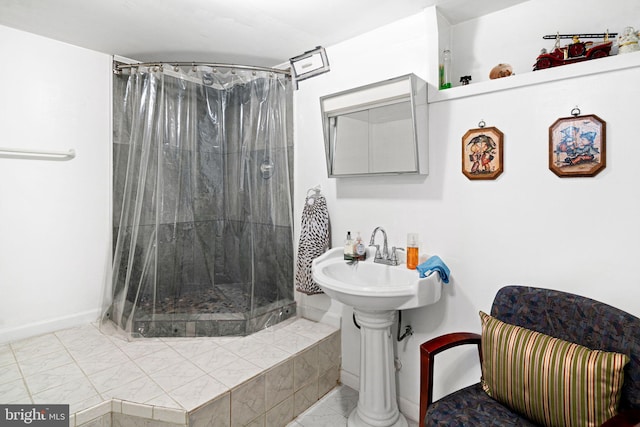 full bathroom featuring a shower stall and baseboards