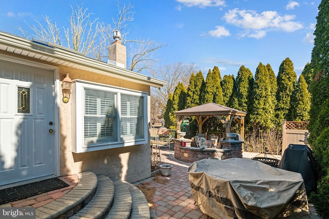 view of patio / terrace featuring a gazebo, area for grilling, and fence