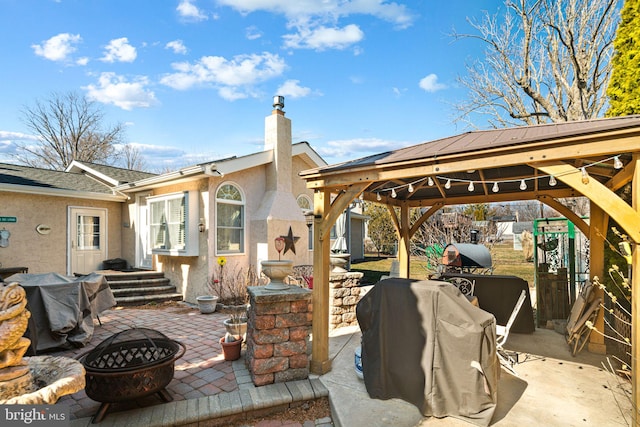 view of patio / terrace with an outdoor fire pit, grilling area, and a gazebo