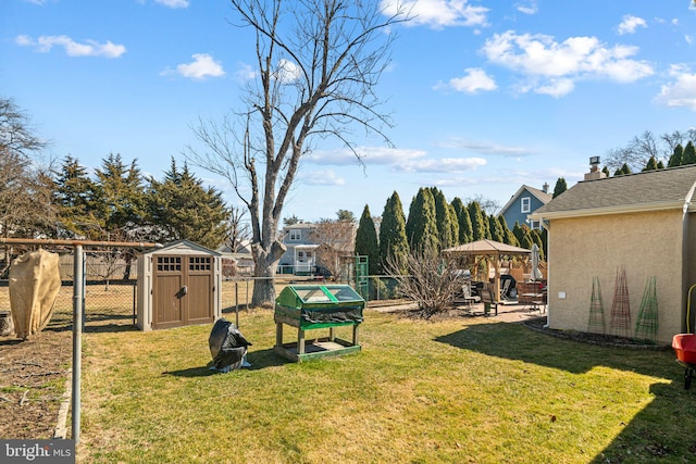 view of yard with a storage unit, a gazebo, a patio area, a fenced backyard, and an outdoor structure