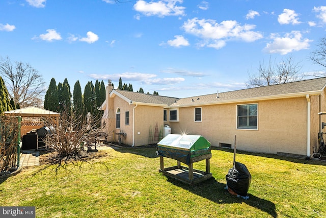 back of property featuring a lawn, a patio, a gazebo, and stucco siding