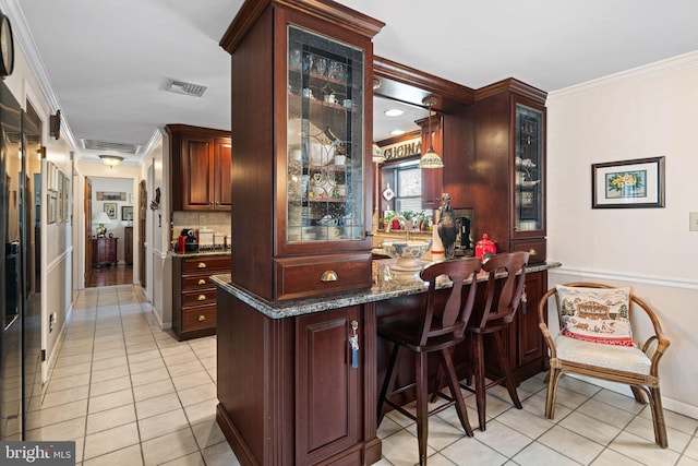 bar with light tile patterned floors, bar, visible vents, tasteful backsplash, and crown molding