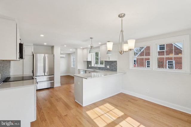 kitchen with light wood finished floors, light countertops, appliances with stainless steel finishes, and a sink