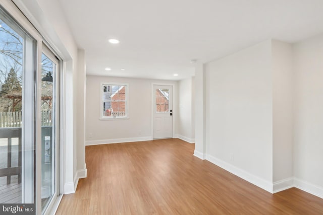 unfurnished room with recessed lighting, wood finished floors, and baseboards