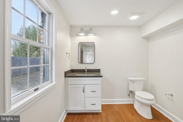 bathroom featuring vanity, wood finished floors, toilet, and baseboards