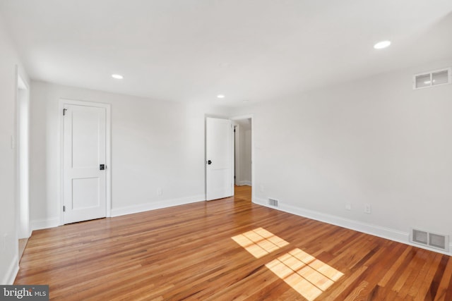 empty room featuring recessed lighting, visible vents, light wood-style flooring, and baseboards