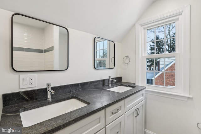 full bathroom with lofted ceiling, double vanity, and a sink