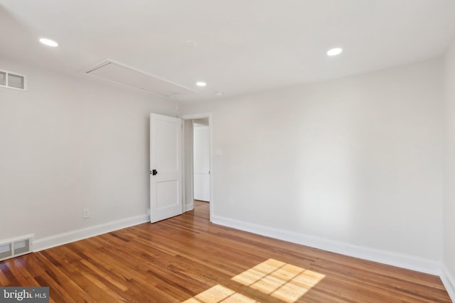 empty room featuring visible vents, baseboards, and wood finished floors