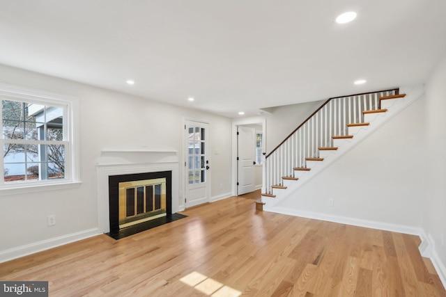 living area with recessed lighting, stairway, baseboards, and wood finished floors