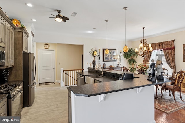 kitchen with visible vents, dark countertops, appliances with stainless steel finishes, crown molding, and a sink