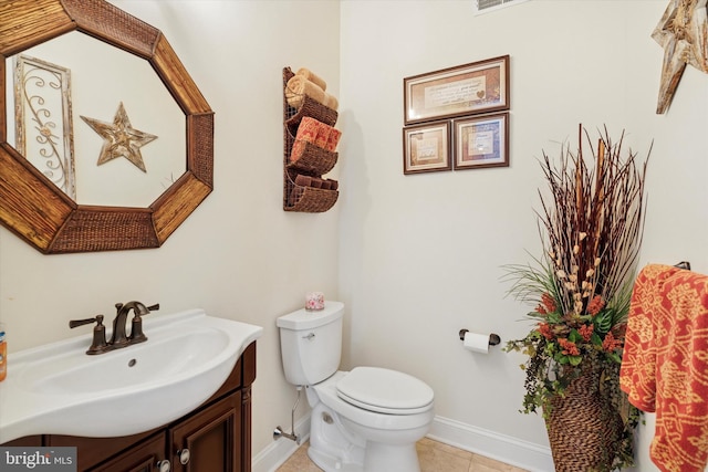 bathroom featuring toilet, tile patterned flooring, vanity, and baseboards