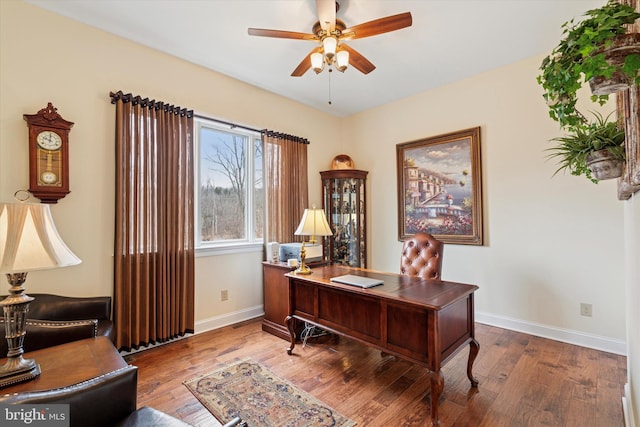 office area featuring a ceiling fan, baseboards, and hardwood / wood-style floors