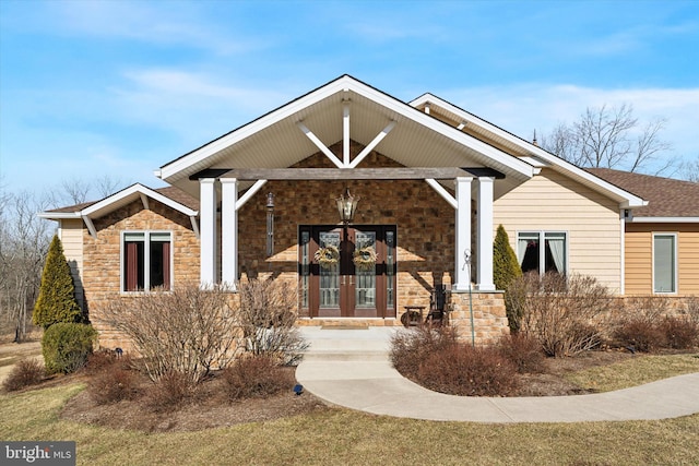 exterior space with stone siding and french doors