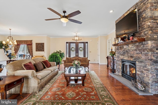 living area featuring crown molding, plenty of natural light, a fireplace, and wood finished floors