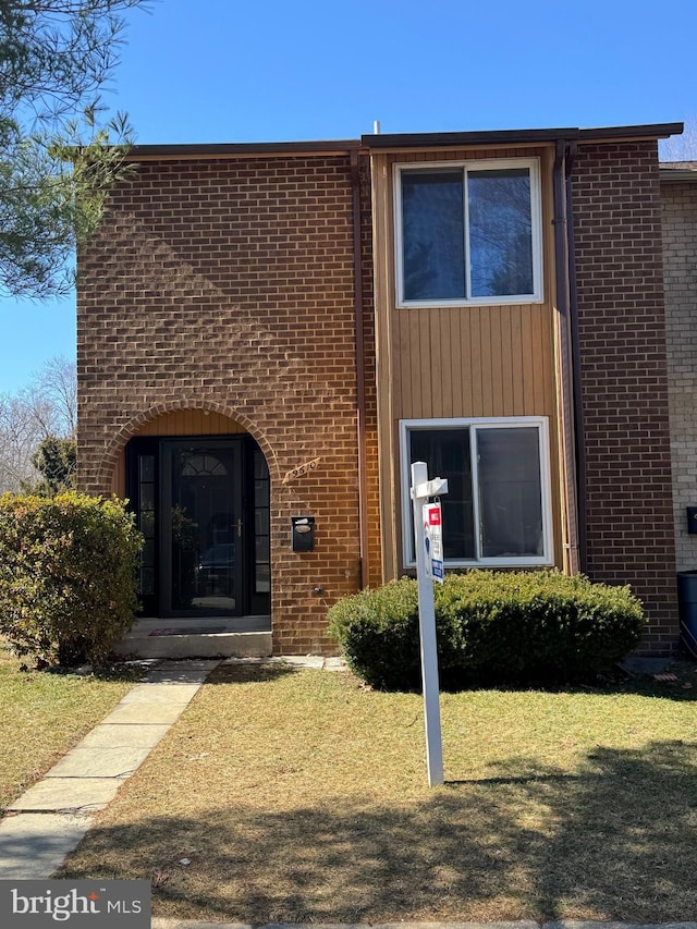 view of front of house with a front lawn and brick siding