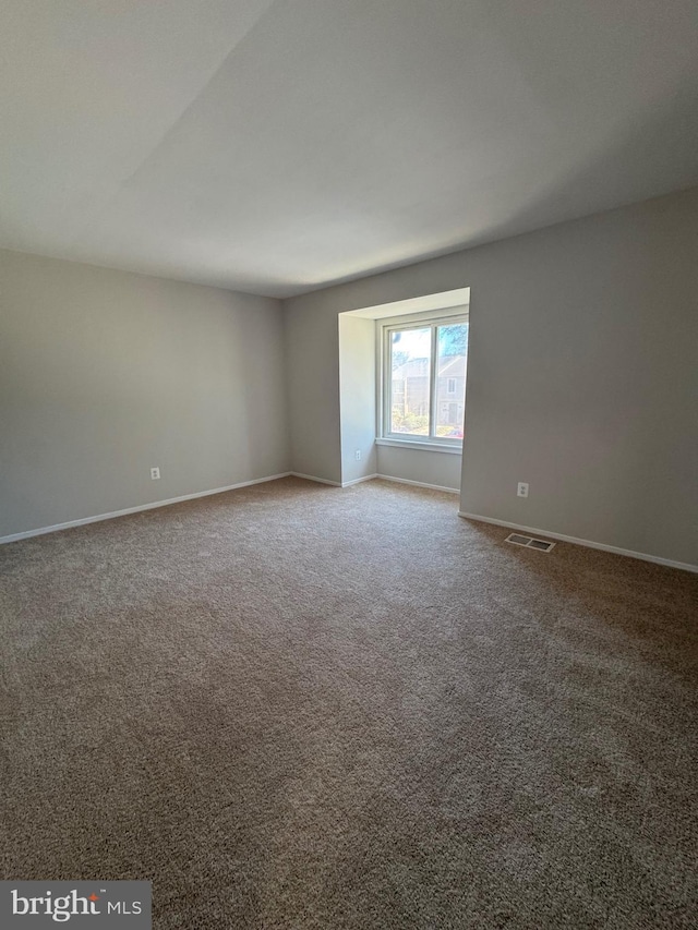 carpeted empty room with visible vents and baseboards