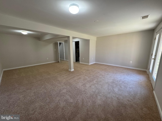 basement featuring carpet, visible vents, and baseboards