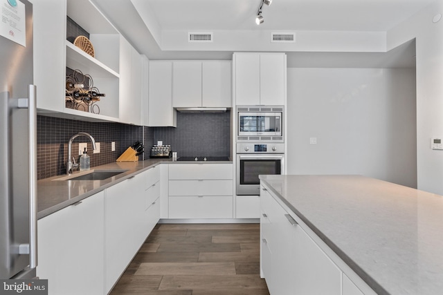 kitchen featuring stainless steel appliances, visible vents, a sink, and open shelves