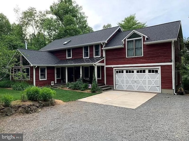 traditional-style house featuring driveway, a porch, and an attached garage