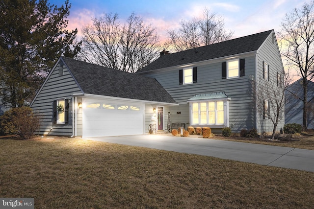 traditional home featuring a garage, a shingled roof, driveway, a chimney, and a front yard