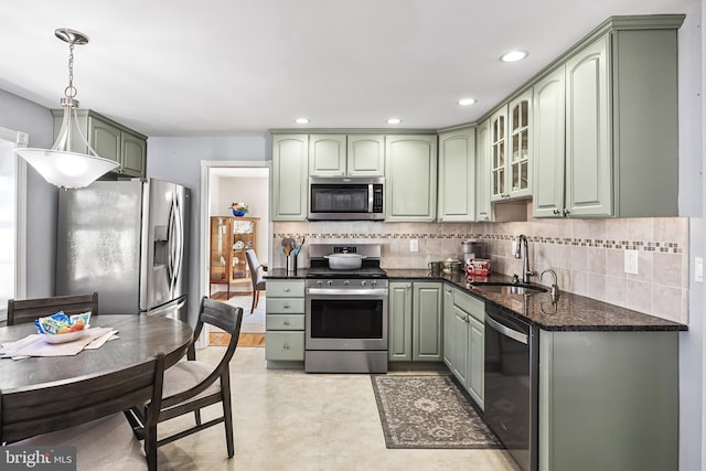 kitchen featuring a sink, backsplash, stainless steel appliances, and green cabinetry