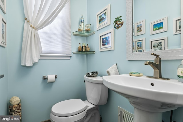 bathroom featuring toilet, visible vents, and a sink