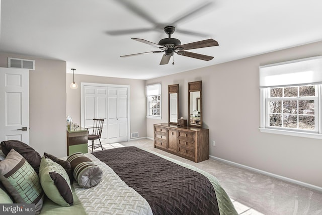 carpeted bedroom with baseboards, visible vents, and a ceiling fan