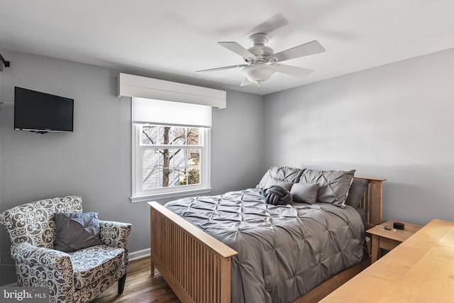 bedroom with ceiling fan, baseboards, and wood finished floors