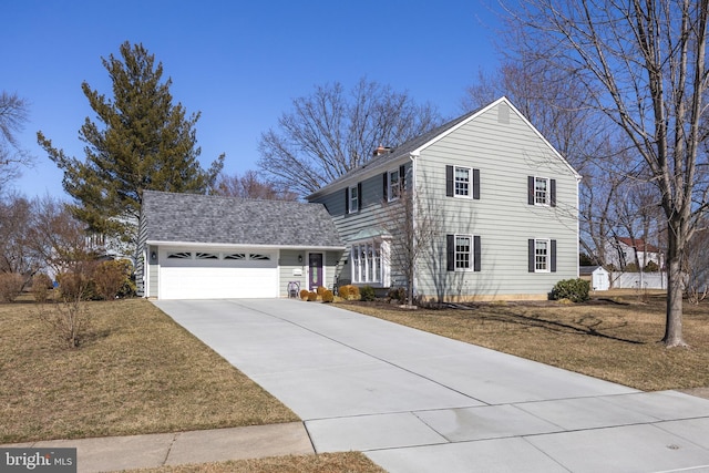 traditional home with a chimney, a shingled roof, a front yard, a garage, and driveway