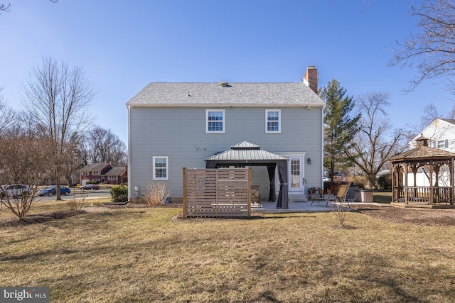 rear view of property featuring a yard, a patio area, a chimney, and a gazebo