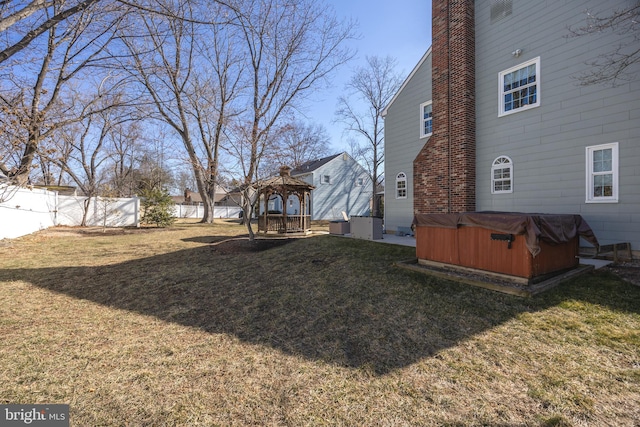 view of yard with a gazebo, fence, and a hot tub