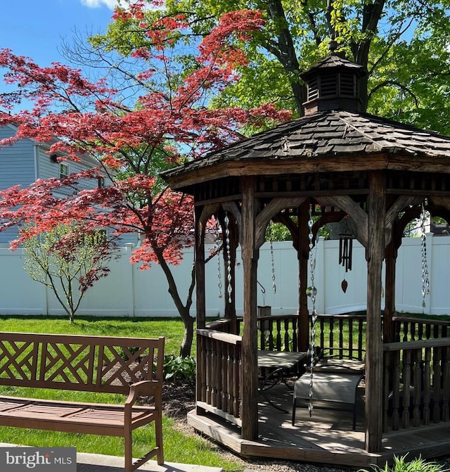 view of property's community featuring a wooden deck, fence, and a gazebo