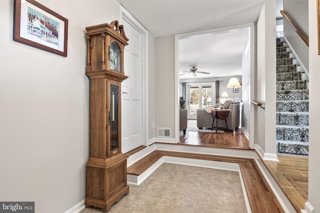 interior space featuring visible vents, stairway, baseboards, and wood finished floors