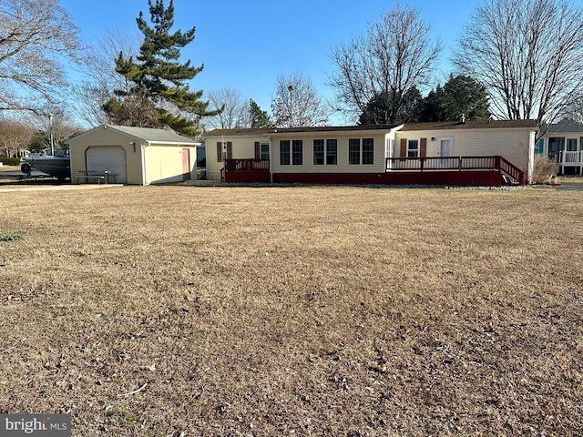 view of front of house featuring a garage, an outdoor structure, a wooden deck, and a front yard