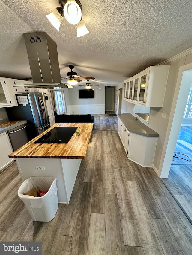 kitchen featuring butcher block countertops, dark wood-style flooring, white cabinets, and black electric stovetop