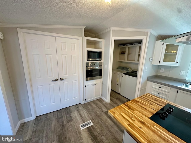 kitchen featuring white cabinetry, appliances with stainless steel finishes, and washer and clothes dryer