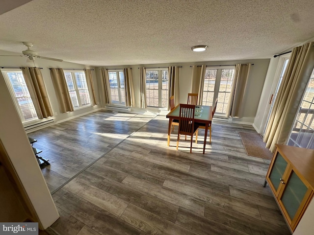 dining room with baseboards, dark wood finished floors, and a textured ceiling